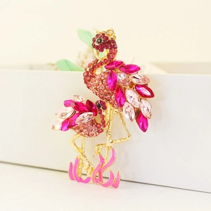 Kreative Flamingo-Brosche mit rosa Kristallen und Goldfinish auf weißem Schmuckkästchen