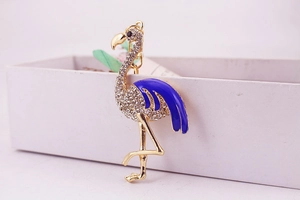 Vue macro d'un porte-clés flamant avec ailes en émail bleu et strass brillants