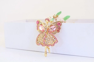 Gros plan du porte-clés ange doré avec cristaux roses sur un coffret cadeau blanc
