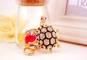 Detailansicht goldener Schildkröten-Schlüsselanhänger mit Strass und schwarzer Emaille