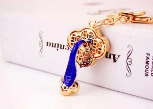 Detailed view of traditional Chinese Ruyi keychain with gold plating and blue enamel work