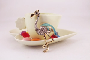 Vue macro d'un porte-clés flamant rose doré orné de strass brillants sur une tasse