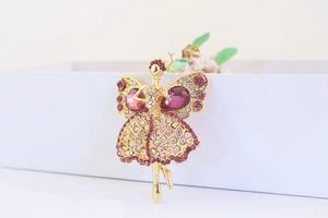 Gros plan détaillé d'un pendentif ballerine doré orné de strass violets et blancs