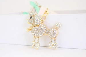 Detailed macro view of poodle keychain with white rhinestones and gold lobster clasp