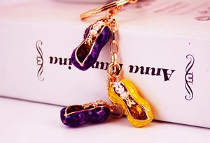 Macro shot of colorful enamel peanut keychain with gold plating and sparkling crystals