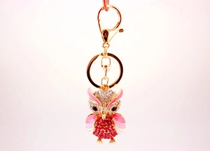 Close-up of golden owl keychain with pink rhinestones and gradient enamel detail
