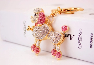 Close-up of poodle keychain with pink and white crystals on a gold metal base