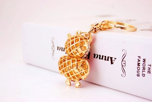 Detailed macro view of crystal owl keychain on a book with golden lobster clasp and ring