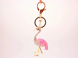 Détail du porte-clés flamant rose doré avec ailes en émail rose et cristaux brillants