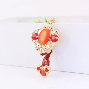 Golden Ruyi charm keychain with orange cat eye stone and red decorative texture