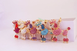 Row of five sparkling rhinestone poodle keychains in red, silver, purple, blue, and pink