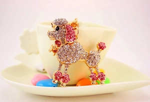 Detail of a sparkling pink and white rhinestone poodle keychain hung on a coffee cup