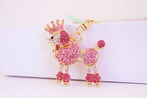 Close-up of a golden poodle keychain with pink rhinestones and a crown charm