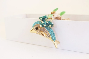 Close-up of golden dolphin keychain featuring blue rhinestones and bow details