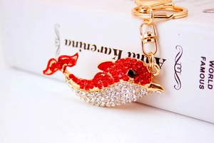 Detailed close-up of a sparkling dolphin keychain with red and clear rhinestones