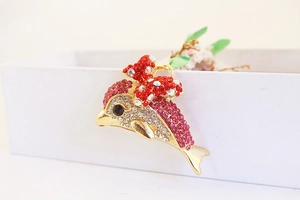 Detailed close-up of a sparkling gold dolphin keychain with rhinestones and a red bow
