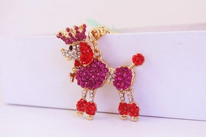 Close-up of golden poodle keychain featuring vibrant red and pink rhinestones with a small crown