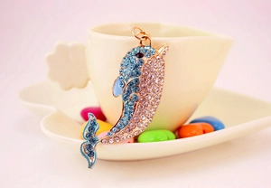 Detailed view of gold-tone dolphin keychain with sky blue rhinestones and gems