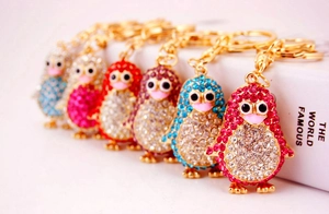 Close-up of cute rhinestone penguin keychains in various colors with metal lobster clasps