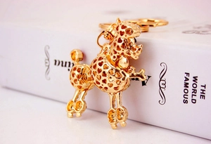 Detailed close-up of golden poodle keychain with hollow heart patterns on metal alloy