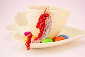 Detail of crystal dolphin keychain with red rhinestones and golden metal hardware