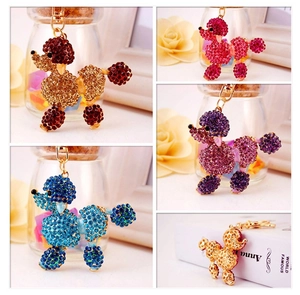 Macro shot of colorful rhinestone-encrusted poodle keychains with gold-tone metal hooks