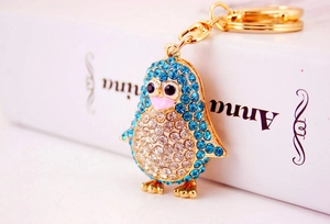 Close-up of blue and white rhinestone penguin keychain with gold plating and pink beak