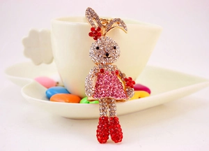 Close-up of cute rabbit keychain with pink and white rhinestones on gold metal base