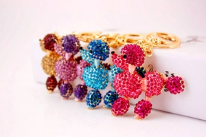 Detail of poodle keychains with colorful crystals in pink, blue, purple and gold
