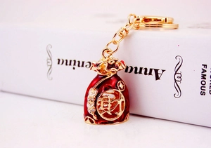 Detail of red and gold Chinese lucky money bag keychain with crystal accents and wealth symbol