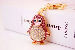 Detail of penguin keychain showing purple and white rhinestones and gold-plated hardware