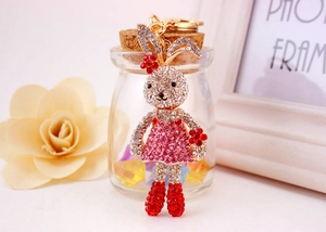 Close-up of cute cartoon bunny keychain with pink and white rhinestones on gold ring