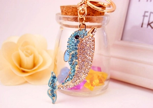 Detail of dolphin keychain with blue rhinestones, gold-tone finish and lobster clasp