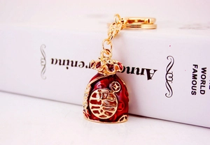 Close-up of red enamel lucky bag keychain with gold Fu character and rhinestones