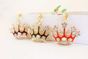 Macro view of crystal crown keychains in purple, black, and red with gold alloy