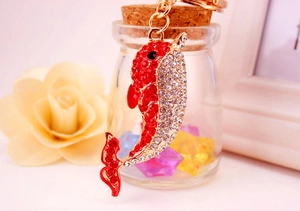 Detailed close-up of a sparkling dolphin keychain with red and white rhinestones