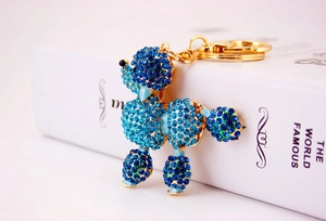 Detailed macro view of the blue rhinestone-encrusted poodle keychain with golden clasp