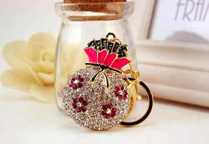 Exquisite gold fortune bag keychain with purple and white rhinestones and pink enamel