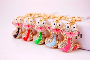 Détail de cinq porte-clés serpent colorés avec strass brillants et finition émaillée