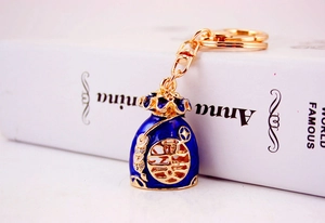 Detailed close-up of dark blue enamel lucky bag keychain with gold-plated accents