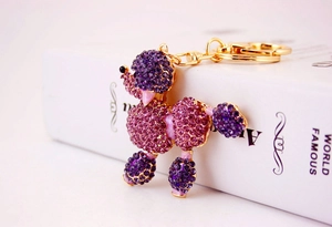 Macro view of purple rhinestone poodle keychain with golden metal clasp and ring
