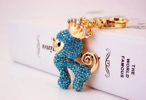 Makroaufnahme eines blauen Strass-Pudels Schlüsselanhängers mit goldener Krone Details