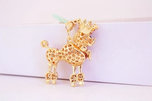 Detail of golden poodle keychain with hollow heart patterns and red rhinestone crown