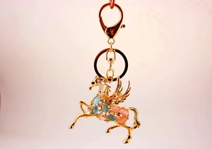 Détail du porte-clés Pégase doré avec pierres d'opale colorées et strass étincelants