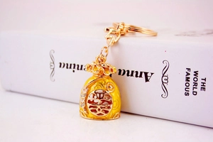 Detail of a golden Chinese lucky bag keychain with yellow enamel and Fu character