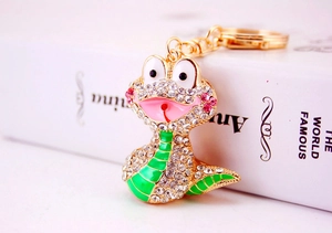 Détail d'un porte-clés serpent mignon avec strass brillants et émail vert coloré
