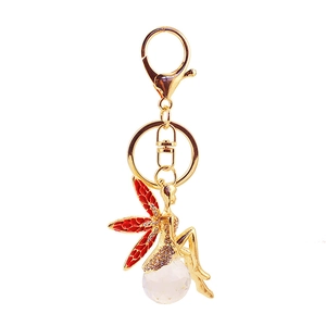 Exquisiter goldener Feen Schlüsselanhänger auf Kristallkugel mit roten Emaille Flügeln und Strass