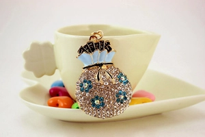 Detail of fortune bag keychain with white rhinestones and blue enamel flowers