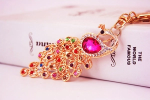 Detail of colorful peacock keychain with vibrant rhinestones and golden lobster clasp