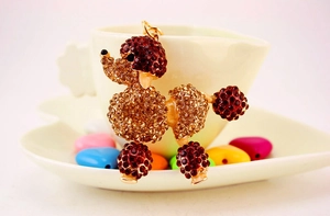 Macro shot of cute poodle keychain with brown rhinestones and golden hardware